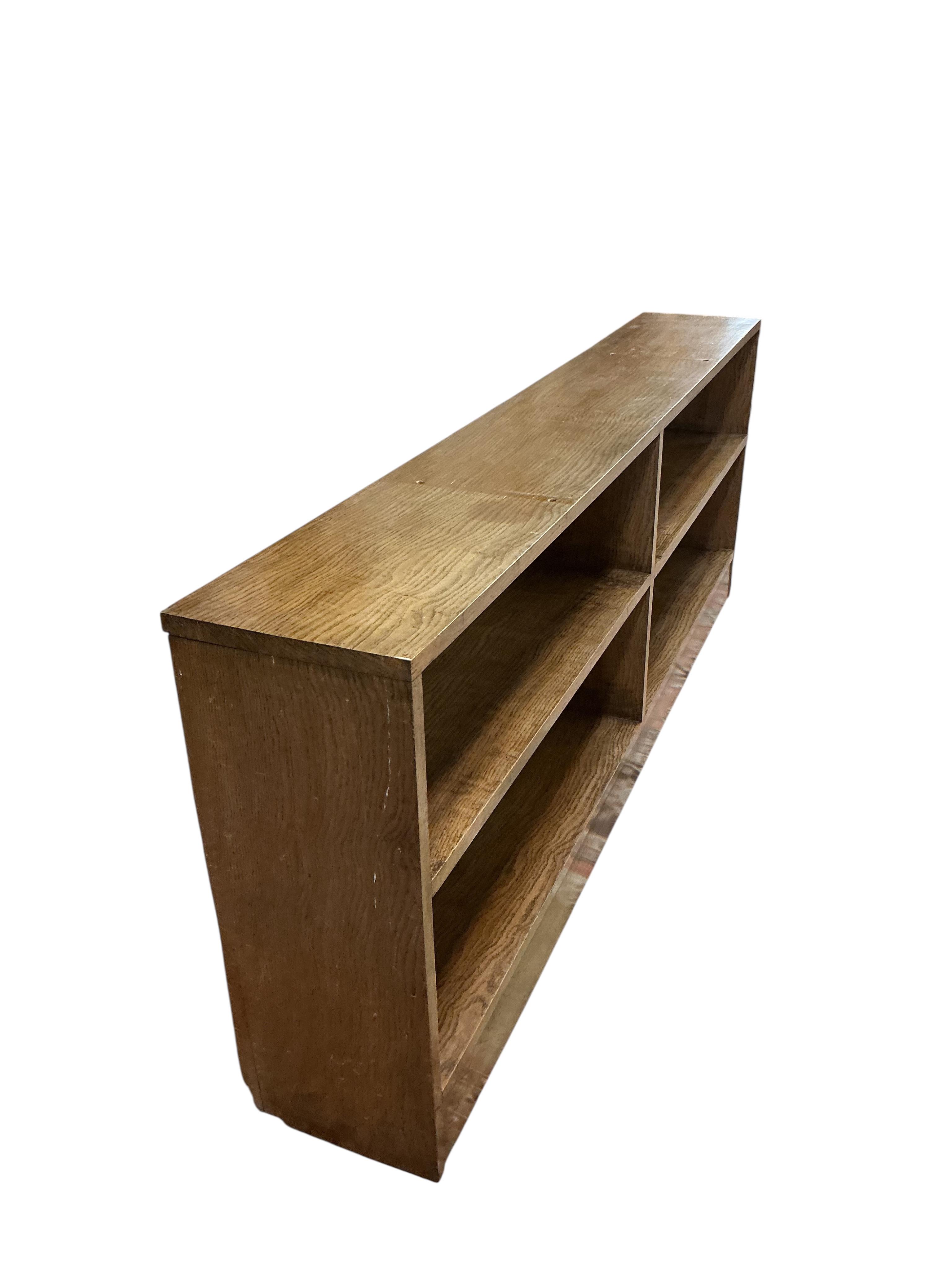 A mid century oak dwarf open bookcase, width 176cm, depth 27cm, height 67cm